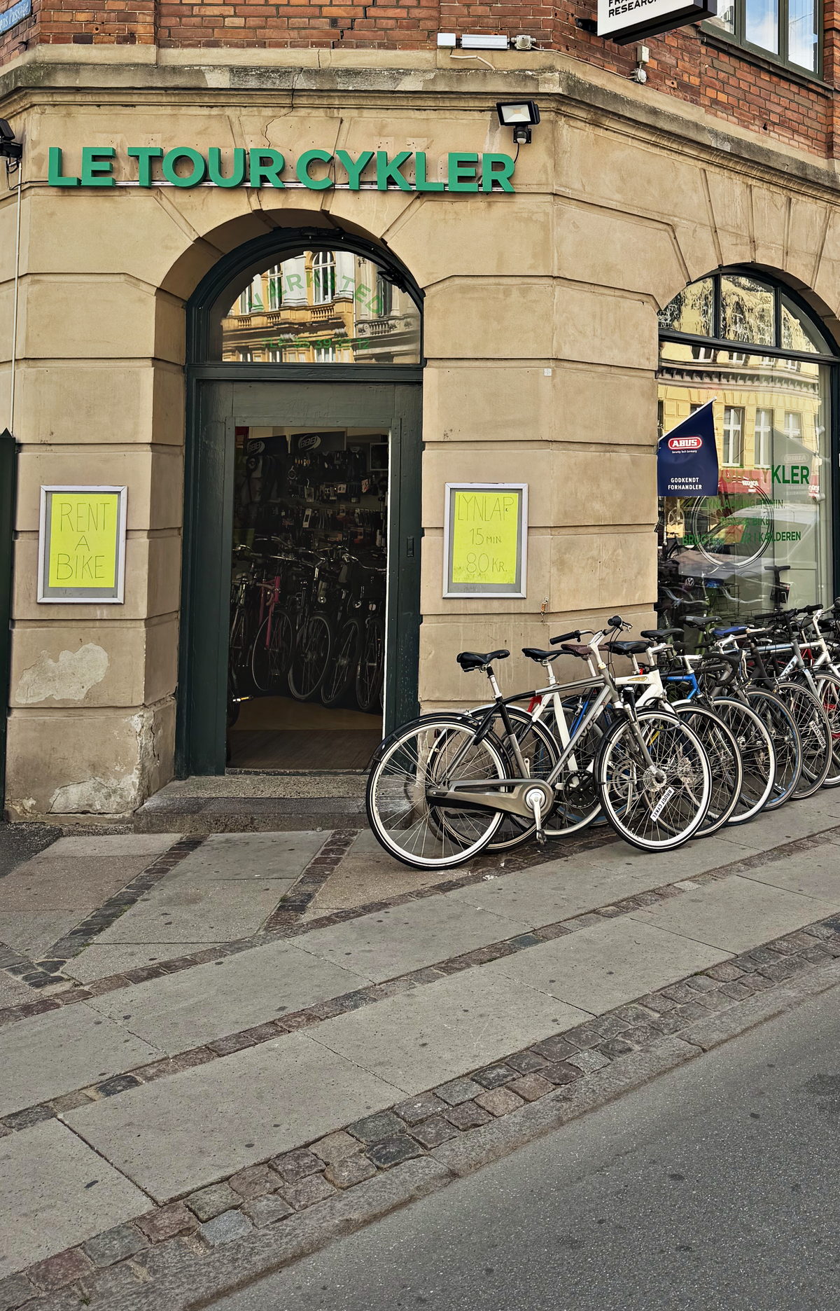 Facaden på Le Tour Cykler på hjørnet af Fælledvej på Nørrebro med cykler stillet op langs muren