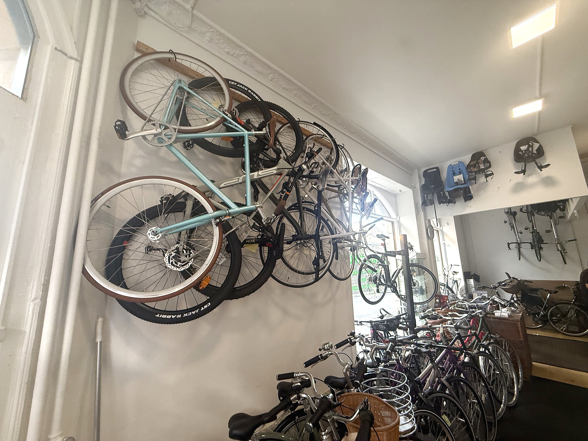 Cykler hængt op på væggen i butikken hos Le Tour Cykler på Nørrebro