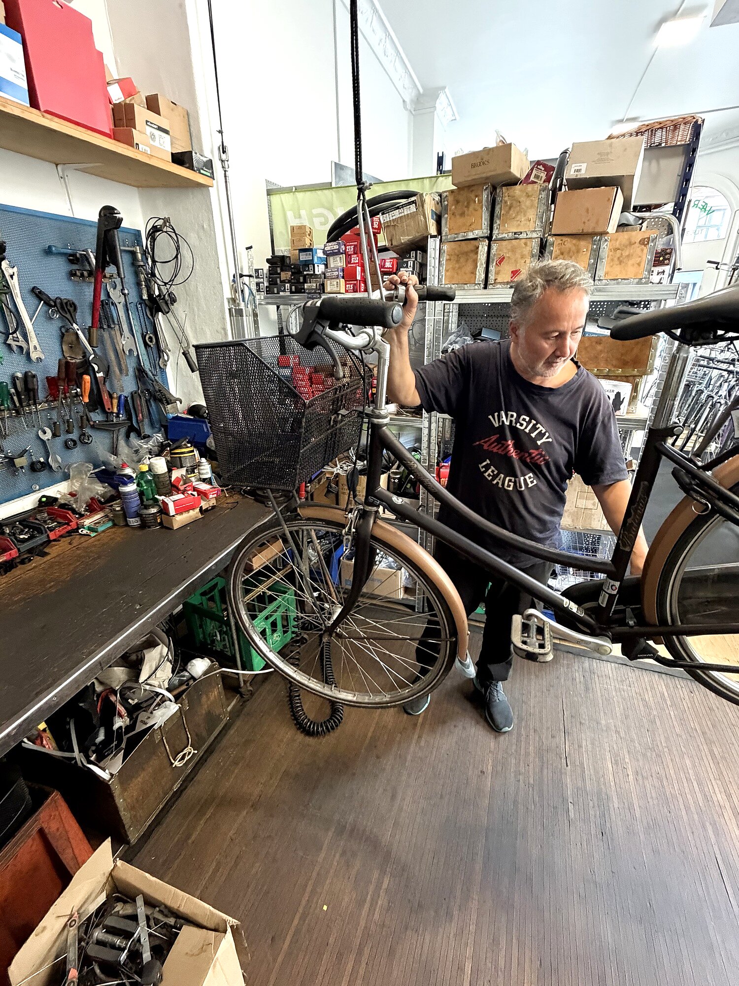 Ejeren Ramazan reparerer en cykel i værkstedet hos Le Tour Cykler